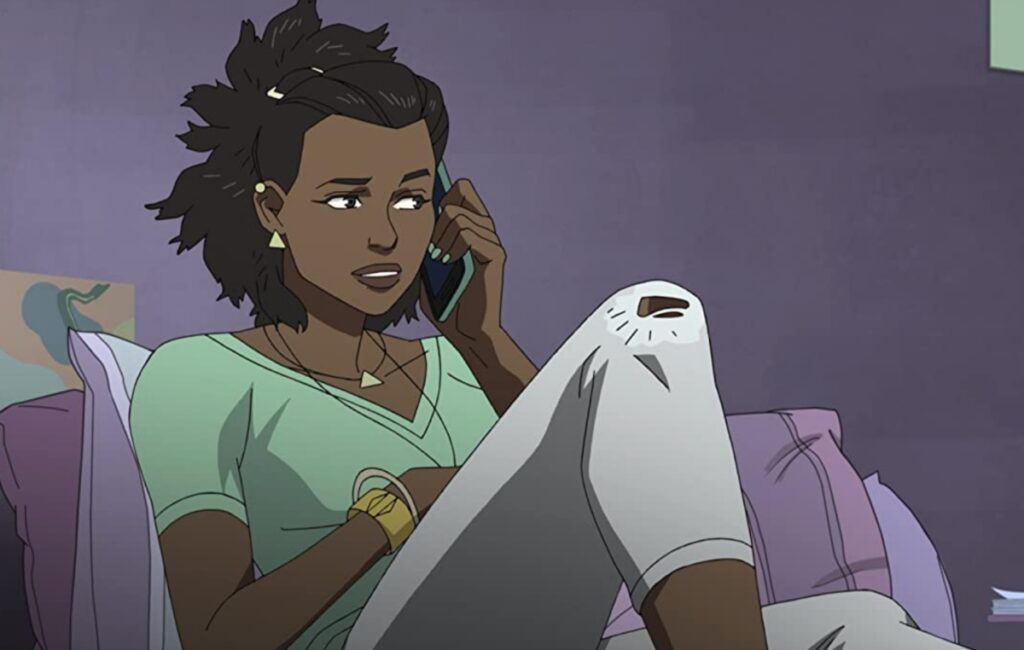 Amber from Invincible. A young, Black girl sitting on the couch in a green t-shirt and white leggings.