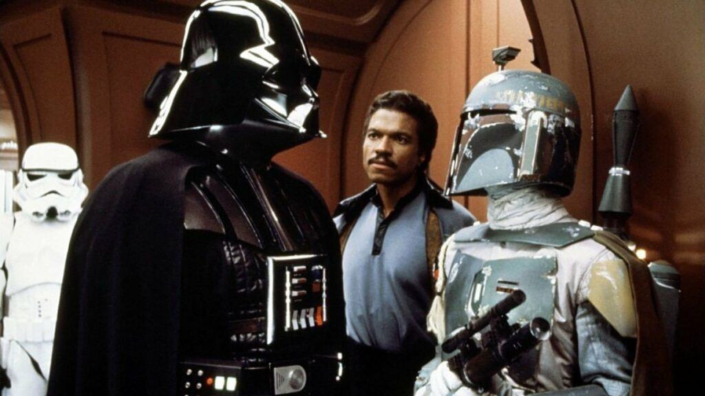 Darth Vader, Lando Calrissian, and Boba Fett in the halls of Cloud City after Boba has called in the location of the Millenium Falcon.